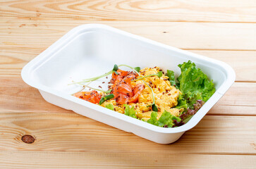 Salmon scramble. Healthy food. Takeaway food.  On a wooden background.