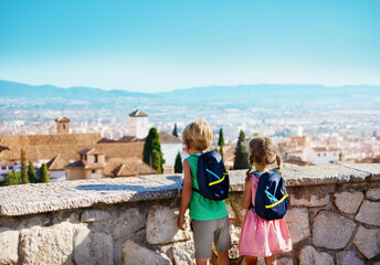 Kids with backpack, boy and girl standing on viewpoint