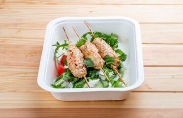 Chicken lula kebab with herbs and vegetables. Healthy food. Takeaway food. On a wooden background.
