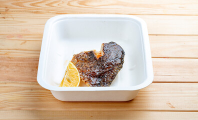 Sea bass fillet. Healthly food. Takeaway food. On a wooden background.