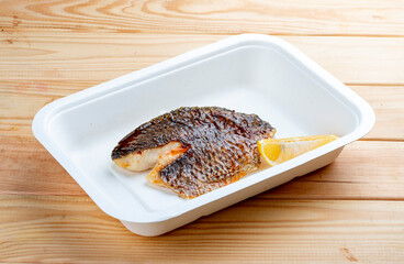 Sea bass fillet. Healthly food. Takeaway food. On a wooden background.
