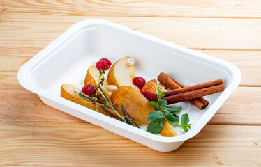 Stewed pear in spices with nuts. Healthy food. Takeaway food.  On a wooden background.