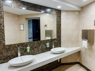 Property with wood wall, twin sink fixture, spacious mirror and interior design