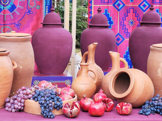 still life with pomegranate grapes and clay jugs of wine