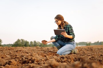 Woman farmer checking soil health before growth a seed of vegetable or plant seedling. Agriculture,...