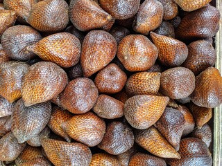 Salak Fruit (Salacca zalacca) - Large amounts of snake fruit. Fresh snake fruit on the wood. Thorny Palm