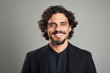 Portrait of a handsome man with curly hair over grey background.