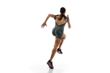 Fototapeta na wymiar Sportive young woman, runner athlete in motion, training, running against white studio background. Speed and endurance. Concept of sport, active and healthy lifestyle, sportswear, competition