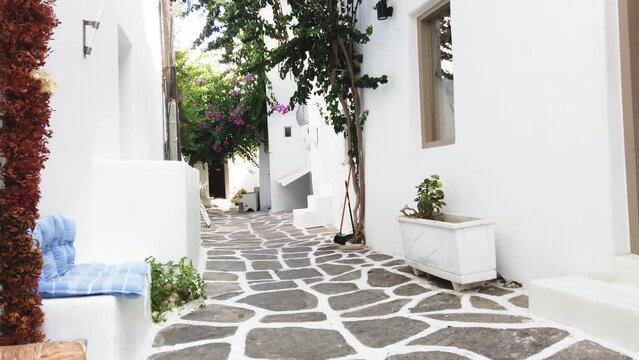 Naoussa typical white street leading to sea with sunshine, small village on Paros island, Greece