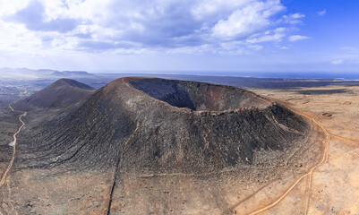 Mid aspect aerial distance panoramic image of Volcan Calderon Hondo volcano and volcanic crater near Corralejo and Lajares, Fuerteventura, Canary Islands, Spain
