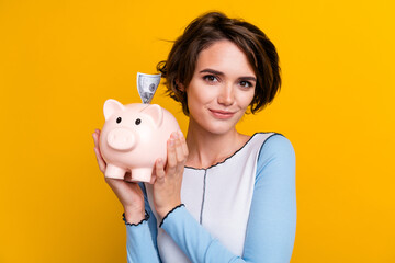 Photo of positive charming woman wear top collecting cash money box isolated yellow color background