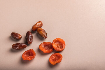Date fruits and dried apricots on a beige background.Islamic religion and Ramadan concept.Traditional, tasty and healthy Ramadan.
