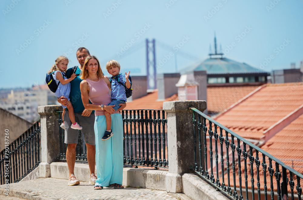 Wall mural Happy family with kids enjoy Lisbon viewpoint in summer