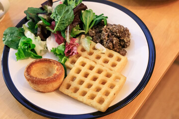 A Balanced Meal: Fresh Salad, Savory Meat, and Golden Waffles