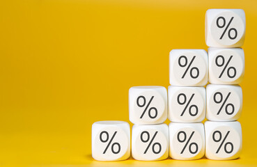 Concept of interest rate and mortgage rates. Hand putting a wooden cube block on top, representing growth