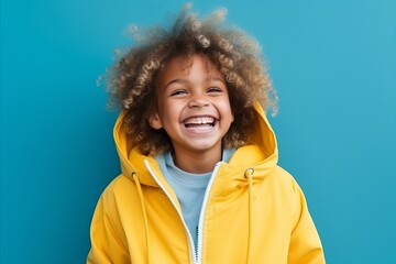 Little african american girl in a yellow jacket on a blue background