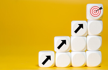 block with target aiming dart board and arrow up on yellow background. Business achievement...
