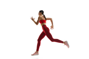 Fototapeta na wymiar Dynamics, endurance and energy. Female runner athlete in motion, running, training against white studio background. Concept of sport, active and healthy lifestyle, sportswear, competition