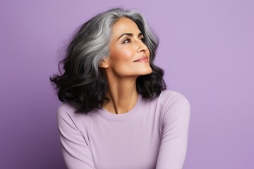 Portrait of a beautiful woman with grey hair on a purple background