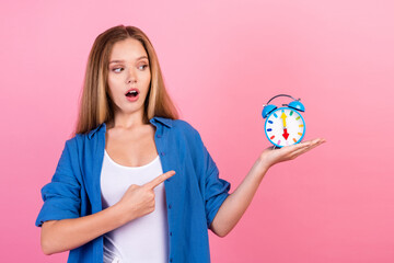 Photo of funky excited lady dressed blue shirt looking pointing finger watch isolated pink color...