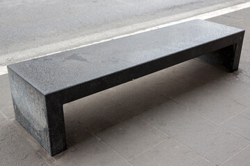 Close up of an empty concrete bench. There's no one sitting there