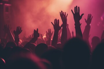 people with hands up at the music festival concert with purple and red light