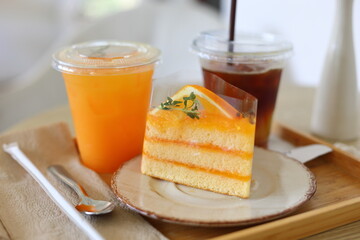 Delicious orange cakes with orange juice are placed on a wooden table in a cafe. Dessert concept....