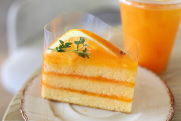 Delicious orange cakes with orange juice are placed on a wooden table in a cafe. Dessert concept