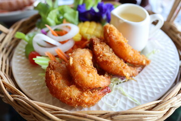 Close-up view of Thai food named fried shrimp salad. Beautifully arranged in white plates and wicker baskets. Looks delicious on the table in a restaurant. Thai food concept. modern