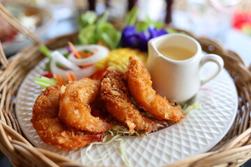 Close-up view of Thai food named fried shrimp salad. Beautifully arranged in white plates and wicker baskets. Looks delicious on the table in a restaurant. Thai food concept. modern