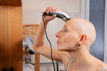 Hairless lady after cancer treatment shaves head in mirror