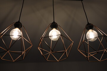 Iron pendant lamps in the shape of a diamond. Stylish lamps in loft style. Hollow chandeliers in the bedroom.