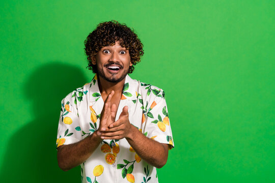 Photo of excited cheerful latin guy dressed print shirt applauding arms palms empty space isolated green color background - Powered by Adobe