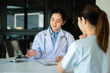  Female doctor filling up an application form while consulting patient. Medicine and health care...