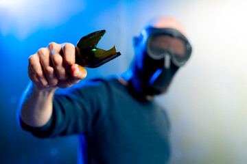 male robber in a mask holding a broken bottle in his hand threats attack robbery