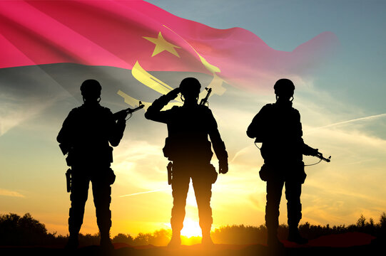 Silhouettes of a soldiers with the Angola flag against the sunset. Concept - Armed Force