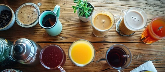 Various drinks on a wooden table, including tea, milk, juice, coffee, smoothie, water, pot, tray, and tissue, representing healthy and traditional tastes. - obrazy, fototapety, plakaty