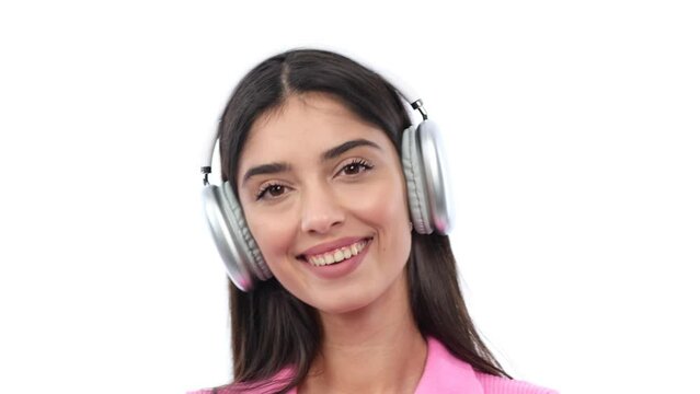 Portrait of a satisfied, happy Caucasian woman listening to music on headphones and dancing, relaxing and resting on white background.