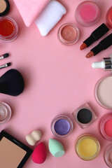 Various colorful beauty products on bright pink background. Top view.