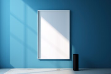 A black frame on a wall with a shadow