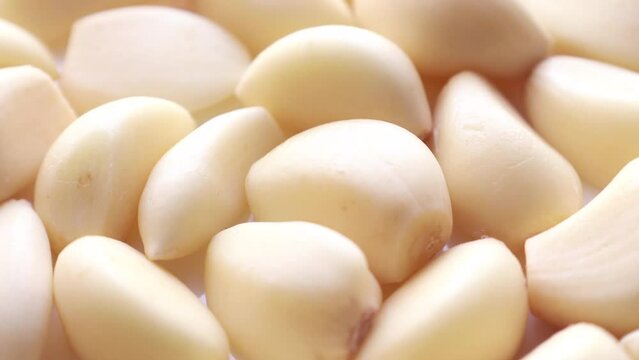 Fresh whole white garlic cloves circle rotation close up