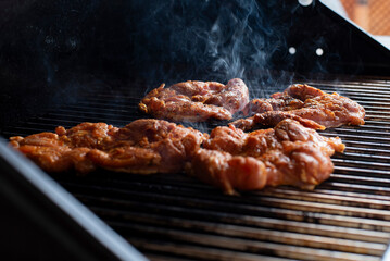 cooking a chicken in the grill in a party outdoors