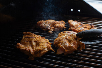 cooking a chicken in the grill in a party outdoors