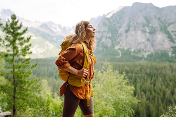 Young woman  hiking girl with backpacks. Hiking in nature. Sunny landscape. A young traveler...