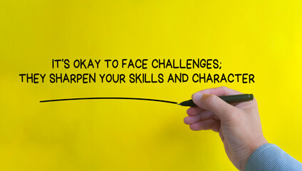 Hand writing It is okay to face challenges affirmation on yellow cover background. Affirmation...