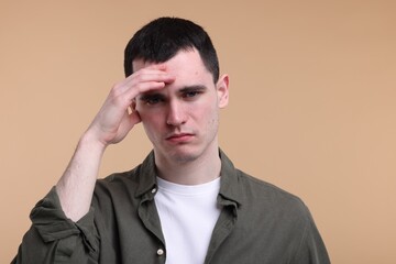 Portrait of sad man on beige background