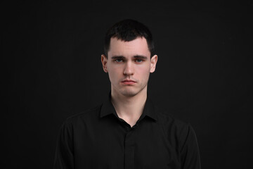 Obraz premium Portrait of sad man on black background