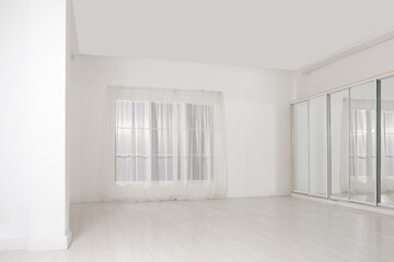 Empty room with white walls and large window