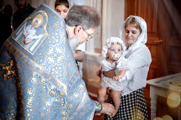 anointing of a small child in an Orthodox Christian church or temple during the sacrament of...