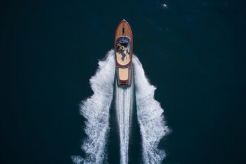 Classic Italian wooden boat fast moving aerial view. A large modern high-speed wooden luxury boat....